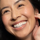Close-up of a woman wearing peach blush on cheek and lip