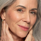 Close-up of a woman with light skin wearing plum blush shade on cheeks and lips