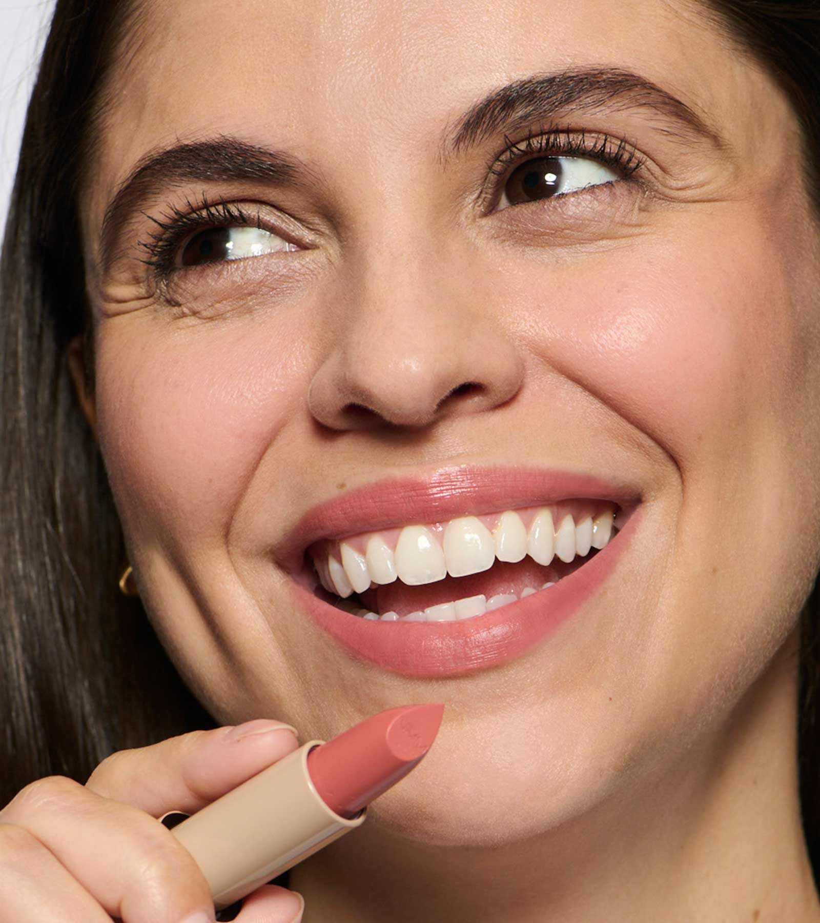 model wearing and holding peach 01 lipstick shade