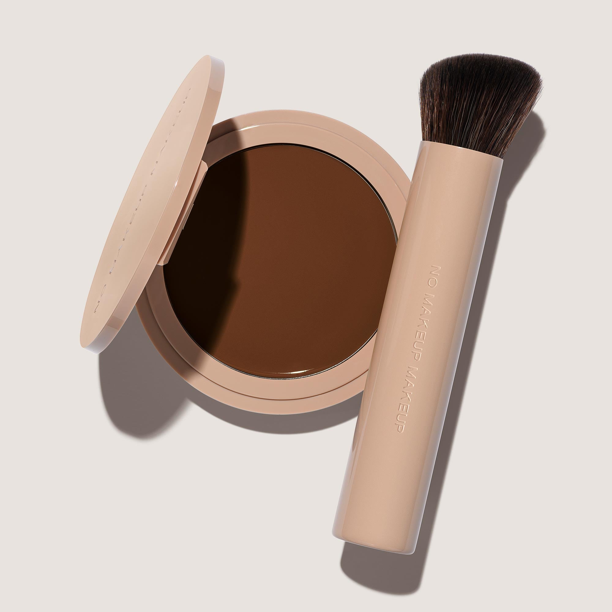 An open FlexShade Foundation by No Makeup Makeup compact in Deep and a brush with the Oprah Daily Beauty O-Wards 2024 seal