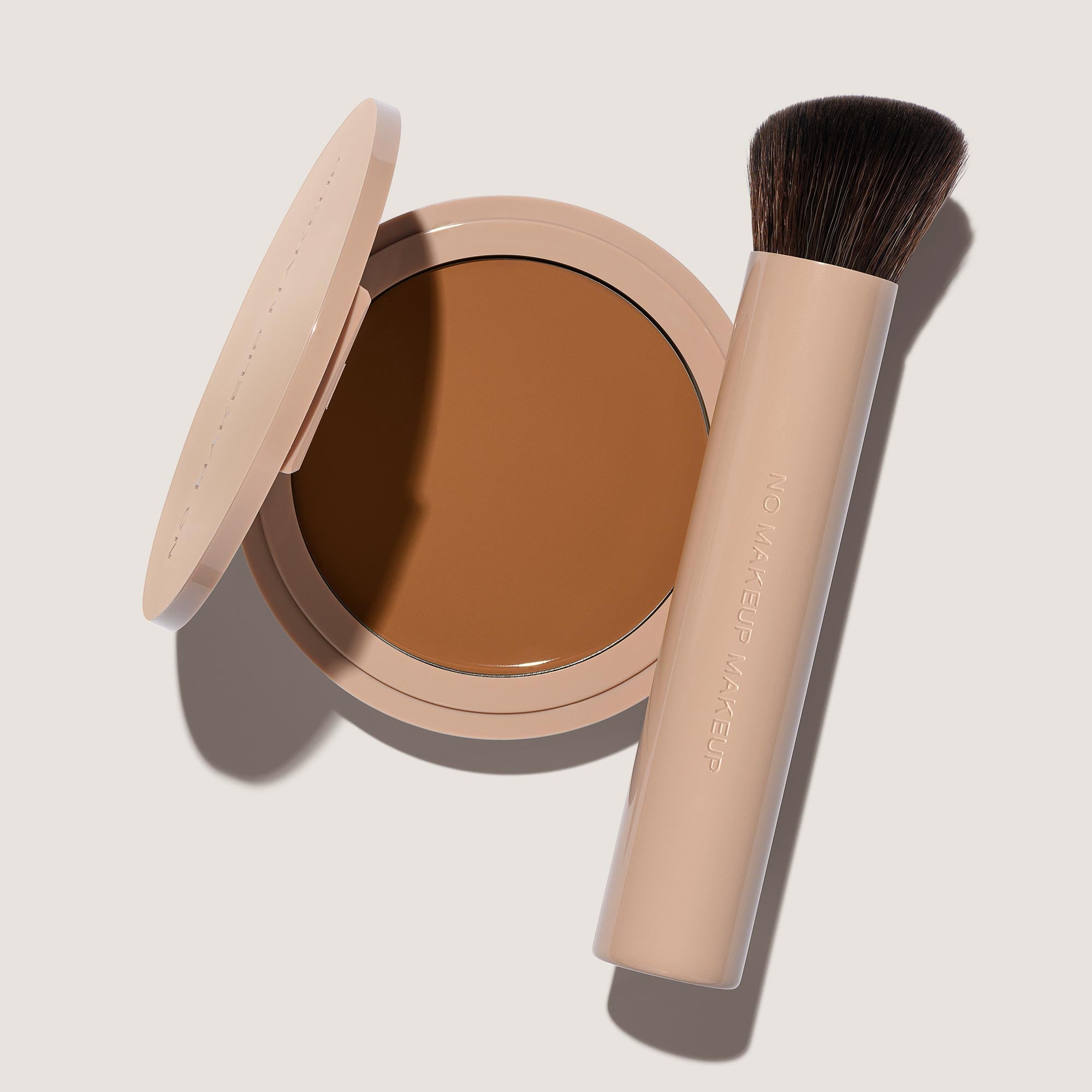 An open FlexShade Foundation by No Makeup Makeup compact in Mocha and a brush with the Oprah Daily Beauty O-Wards 2024 seal