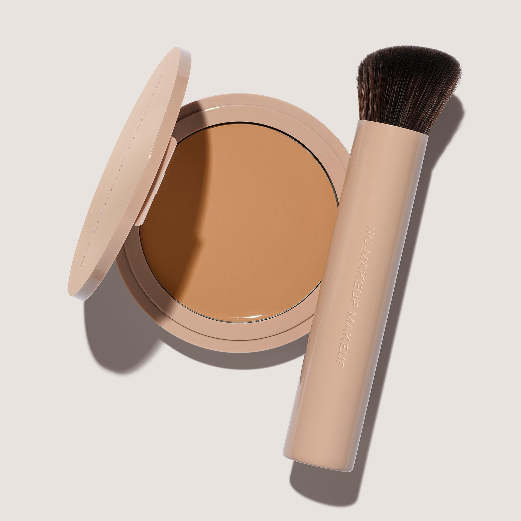 An open FlexShade Foundation by No Makeup Makeup compact in Natural and a brush with the Oprah Daily Beauty O-Wards 2024 seal