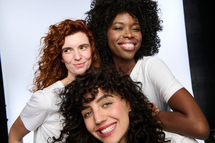 Three women smiling with No Makeup Makeup® — natural, glowing skin with a barely-there makeup look