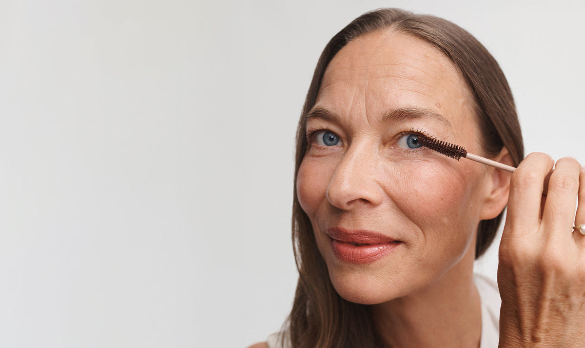 Woman applying Perfect Swipe Mascara to her eye with the wand brush. 