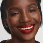 model with dark skin wearing No Makeup Makeup Creme classic lipstick in original red