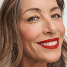 model with medium tone skin wearing No Makeup Makeup Creme classic lipstick in original red