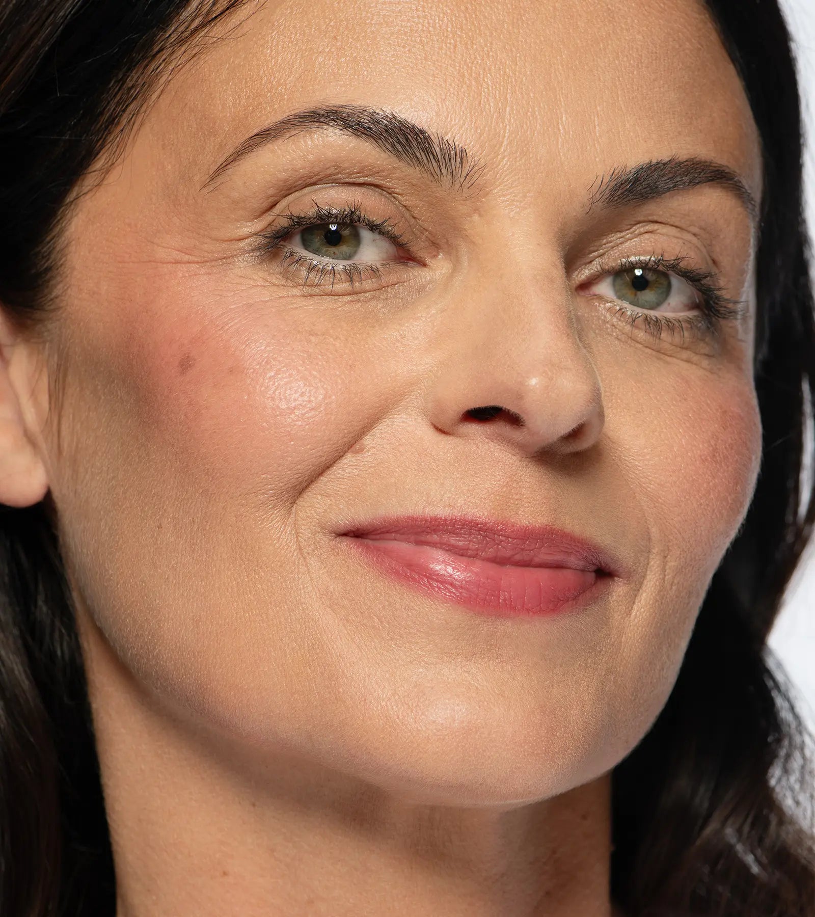 No Makeup Makeup – Close-up of a woman with medium skin wearing plum blush shade on cheeks and lips, natural minimal makeup